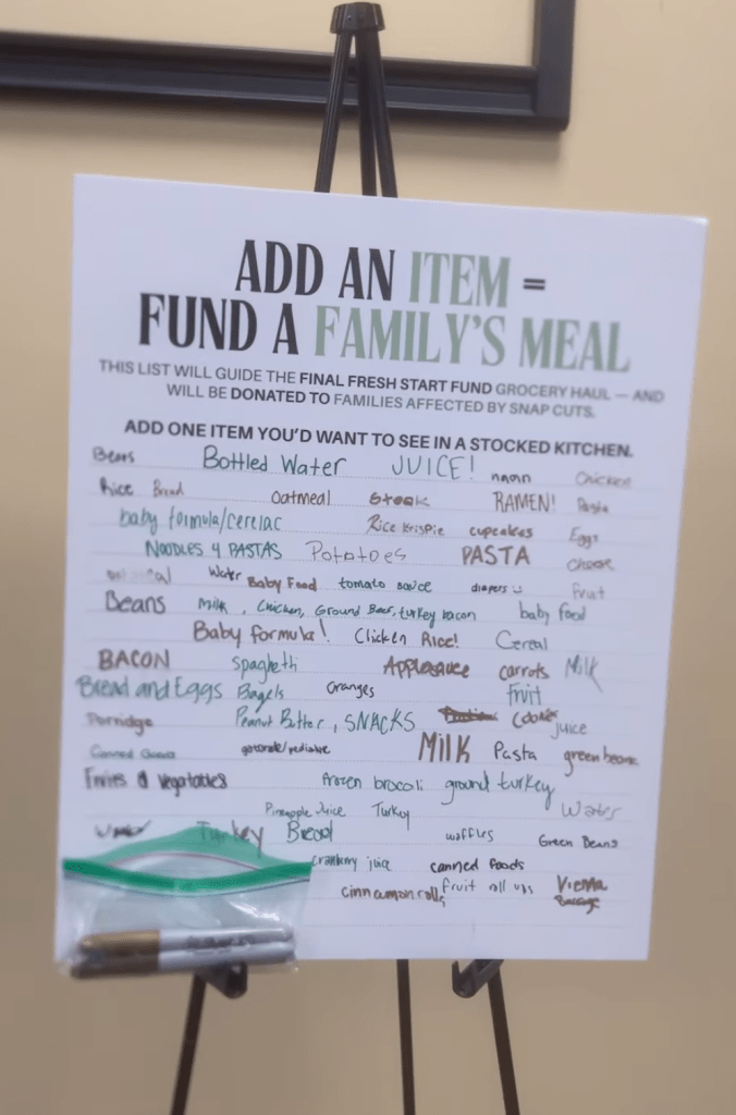 Poster board filled with handwritten grocery items contributed by community members to guide the Fresh Start Fund’s final donation list.