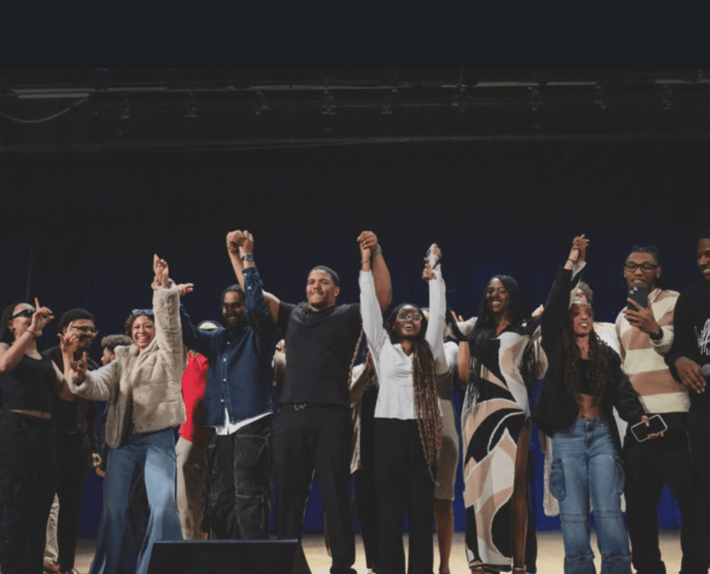 The cast and creative team of Where Grace Finds Us holding hands on stage for their final bow, celebrating the successful student-led production.